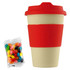 A reusable coffee cup in cream and red with a silicone sleeve, accompanied by a pack of jelly beans.