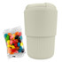 A reusable coffee cup in light beige, accompanied by a bag of colourful jelly beans. The cup features a logo.