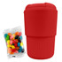 A red reusable coffee cup with a silicone sleeve and a packet of colourful jelly beans beside it.