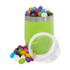 A green coffee cup filled with colourful jelly beans, next to a clear jar containing more jelly beans.