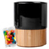 A black ceramic mug with a bamboo base, accompanied by a packet of colourful jelly beans.