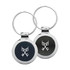 A silver-coloured key ring featuring a round black and grey design with a logo in the centre.