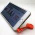 An orange mobile key stand supports a smartphone at an angle, displaying its screen.
