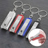 A set of four nail clippers in silver, red, blue, and black, attached to key rings.