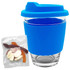 A reusable coffee cup with a blue silicone sleeve and lid, accompanied by a pack of jelly sweets.