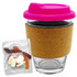 A glass coffee cup with a pink lid and cork band, accompanied by a pack of mixed lollies in various colours.