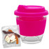 A pink Venice glass coffee cup with a silicone lid, alongside a packet of mixed lollies.
