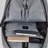 A grey laptop backpack interior featuring compartments for pens, notebooks, a drink bottle, and an umbrella.