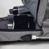 A grey Techpac laptop backpack with a drink bottle, power bank, and books visible inside. It features a logo.