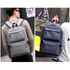 A grey and navy blue laptop backpack featuring multiple compartments and adjustable straps, with a logo on the front.