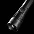 A black outdoor torch with a textured grip and a round head, featuring a circular light source and an on/off button.