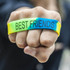 A vibrant silicone wristband in yellow, green, and blue, featuring "BEST FRIENDS" text. The design includes a logo.