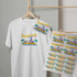 A white t-shirt features a colorful design with palm trees and beach elements, alongside printed transfer sheets on display.