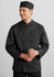 A black long sleeve chef jacket with a buttoned front and a matching chef hat. The model is smiling.