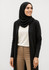A woman wearing a black hijab and a black cardigan over a light top, paired with beige trousers.