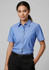 A short-sleeve chambray button-up shirt in blue with a chest pocket, modelled by a woman.
