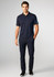 A navy short sleeve polo shirt worn by a model, paired with matching navy trousers and black shoes.