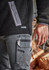 Unisex black Sherpa fleece with zippered pocket, paired with grey work pants featuring cargo pockets and branding.