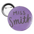 A round 58mm button badge in purple with a silver backing and a pin mechanism.