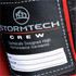A close-up of a label on a red puffer jacket, featuring a logo and space for personal details.