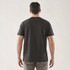 A black short sleeve tee, featuring a simple design and a logo on the back. The model stands facing away from the camera.