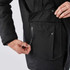 A men's black explorer parka featuring a zippered pocket and a large flap pocket on the front.