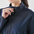 A navy softshell jacket with a high collar and zip closure, featuring a logo on the upper section.