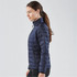 A navy women's jacket with a quilted design, featuring a stand-up collar and zippered pockets, including a small branding element.