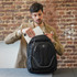 A black Swissdigital Terabyte backpack with blue accents, being opened to store a tablet.