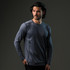 A man models a long-sleeve, navy blue T-shirt featuring a logo. The shirt has a slim fit and subtle detailing.