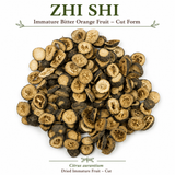 This product image shows the natural appearance of Zhi Shi (Immature Bitter Orange Fruit) in cut form. The dried slices display their characteristic dark brown rind, golden interior, segmented structure, and visible seed cavities. The image helps customers recognize the appearance, texture, and quality of dried Citrus aurantium