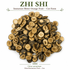 This product image shows the natural appearance of Zhi Shi (Immature Bitter Orange Fruit) in cut form. The dried slices display their characteristic dark brown rind, golden interior, segmented structure, and visible seed cavities. The image helps customers recognize the appearance, texture, and quality of dried Citrus aurantium
