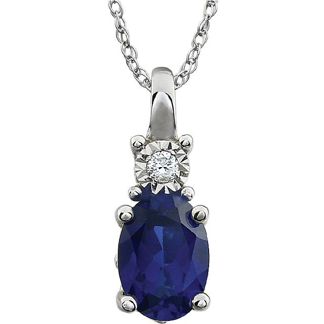 Exquisite 14Kt white gold pendant captures the beauty of a genuine 7x5mm oval Created Blue Sapphire accented by white shimmering diamonds hanging from an 18" inch necklace.Total weight of the diamonds is 0.02 total carat weight.