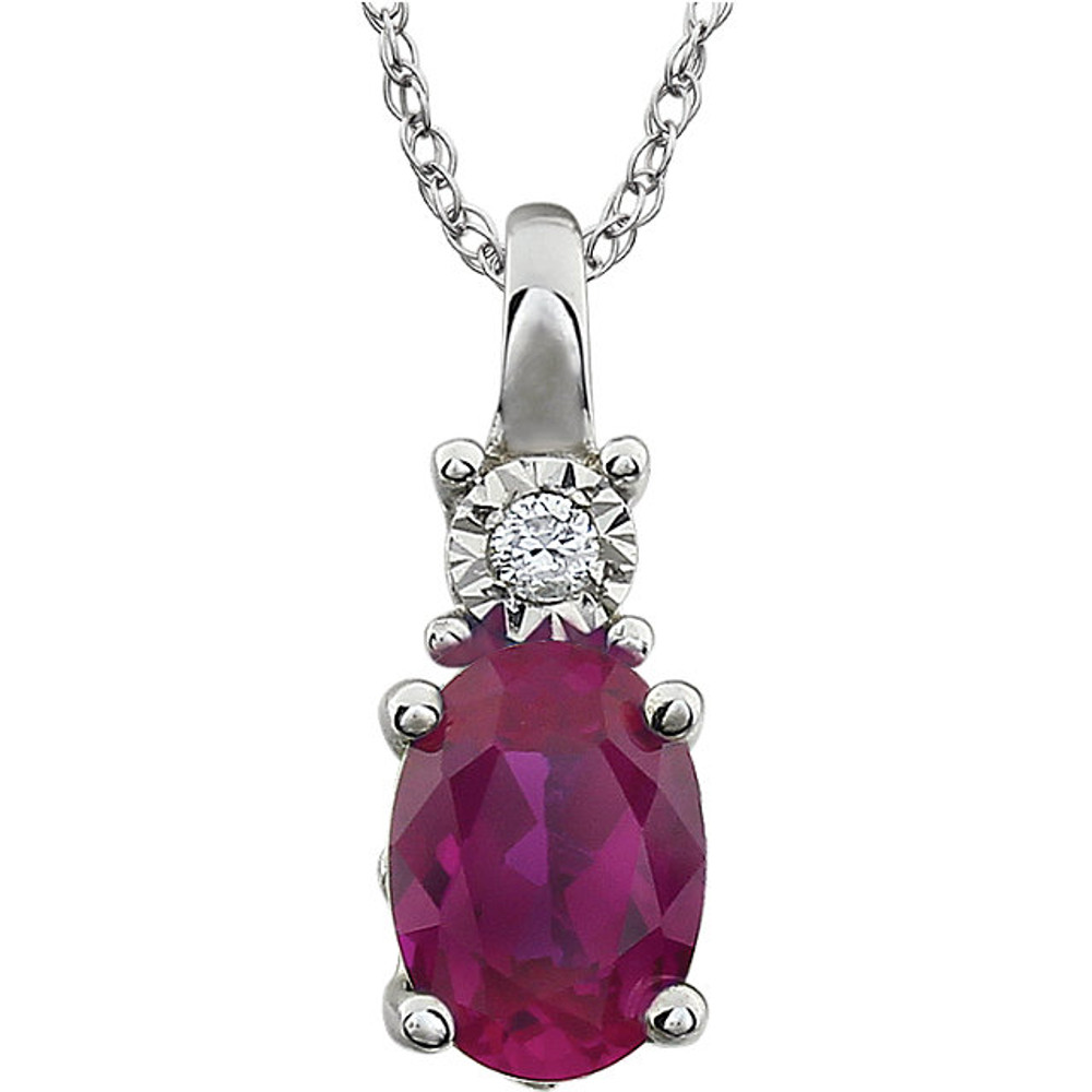 Exquisite 14Kt white gold pendant captures the beauty of a genuine 7x5mm oval Created Ruby accented by white shimmering diamonds hanging from an 18" inch necklace. Total weight of the diamonds is 0.02 total carat weight.