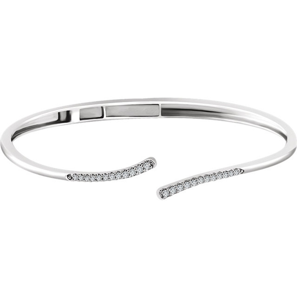 With a graceful bypass design of 14kt white gold, this bangle bracelet elegantly showcases .25 ct. t.w. diamonds. Total weight of the gold is 13.27 grams.