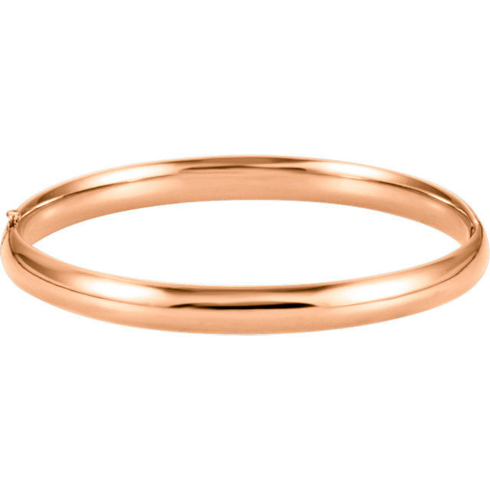 Sometimes the most beautiful things are also the most basic. This hinged style bangle bracelet made from polished 14k rose gold is approximately 6.5mm (1/4 inch) in width by 7 inches in circumference. It has a half round hollow shape and closes with a box clasp.
