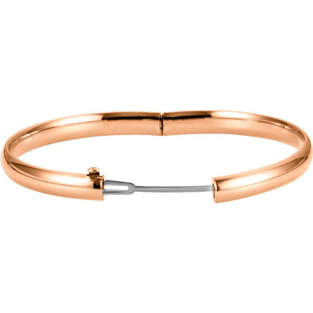 Sometimes the most beautiful things are also the most basic. This hinged style bangle bracelet made from polished 14k rose gold is approximately 6.5mm (1/4 inch) in width by 7 inches in circumference. It has a half round hollow shape and closes with a box clasp.
