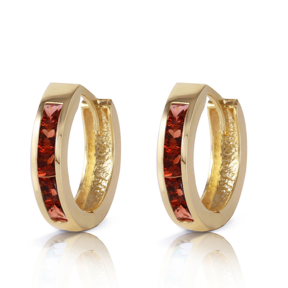 Add color and style to any outfit wit these 14k solid gold hoop huggie earrings with garnets. This classic style looks great when hugging the earlobes and can be worn anywhere. Solid 14k gold ensures that these earrings are of the highest quality. Ten princess cut garnet stones are set in this pair, with a total weight of 1.30 carats. Each garnet has natural inclusions to add to its beauty, while adding sparkle to a traditional style of earrings. These earrings are a perfect purchase for any woman. They also make a perfect birthstone gift for all women blowing out their candles in the month of January.