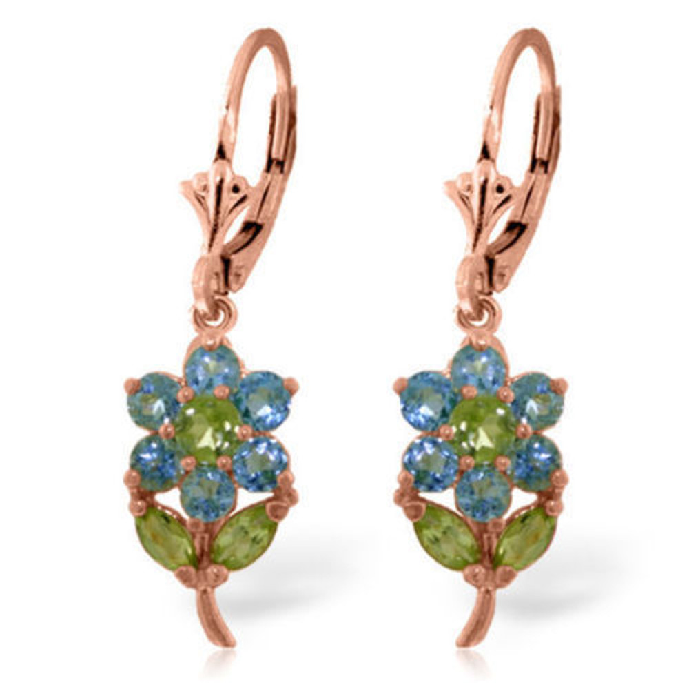 Don a sensational spring look with the light blue and olive green color combination and floral design of the 14k gold Flower Earrings with Blue Topaz & Peridots. In each earring, a round-cut, olive green peridot forms the center of a flower made up of six round-cut blue topazes that act as petals. The floral patterned stones are set in gold, and a gold flower stem is positioned at the base of the flower. This stem features a marquise-cut peridot on each side, with these semiprecious gemstones resembling fresh, spring green leaves. Each complete flower hangs from a leverback clasp.