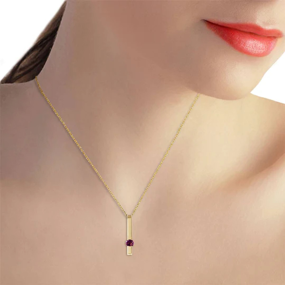 This 14k solid gold necklace with natural purple amethyst is a modern piece that has a drop of feminine color to give it a stylish and colorful look. A classic gold bar is suspended effortlessly from an 18 inch rope chain. The golden pendant has a unique and modern look that is not over the top. One beautiful glowing amethyst stone adds a splash of color to the dazzling gold, with a weight of .25 carat that is not overwhelming. This necklace makes a great piece for the trendsetter who celebrates her birthday in the month of February.