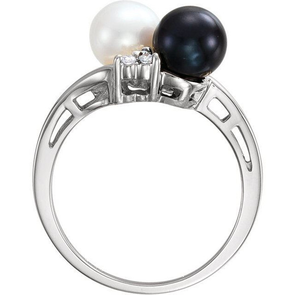 Hand crafted in rhodium plated 14k white gold, this double solitaire ring features black and white Akoya cultured pearls and 6 full cut diamonds. Comes in ring size 7 only