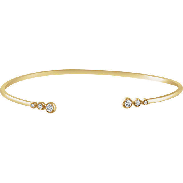 This graduated bangle bracelet showcases round diamonds set in 14k yellow gold.