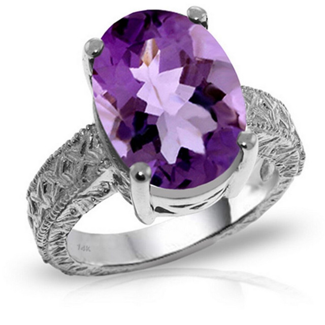 A 14 karat Gold Ring features a glistening Oval shape Natural Amethyst.