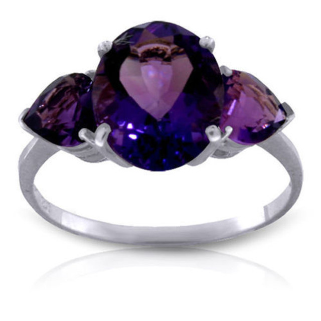 This 14k gold ring with natural amethyst makes a splendid birthday gift for those celebrating in February. This ring brilliantly displays the gorgeous February birthstone that has a classically beautiful look. One oval shaped center stone weighs an amazing three carats for extra sparkle to make her light up. Two radiant heart shaped amethyst stones flank either side of the center stone, adding another carat of beautiful bright purple. The simple white gold band pulls the piece together nicely to make it a classic favorite.