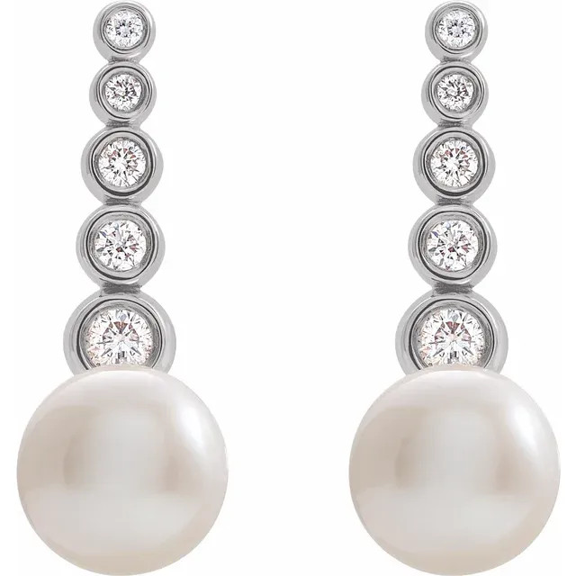 These beautiful pearl earrings feature two lustrous AA+ quality 5.5-6.0mm white freshwater pearls. The pearls are mounted on sterling silver with dazzling I1 clarity diamonds. 