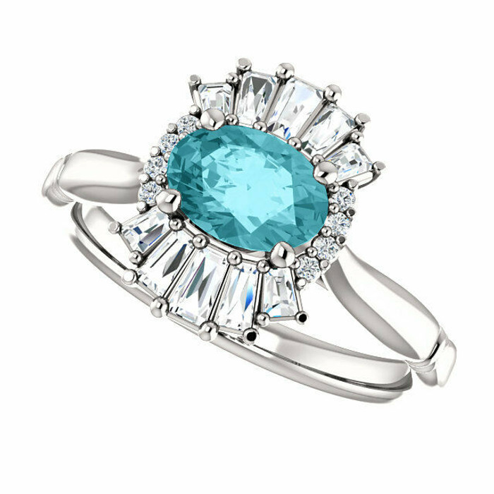 Crafted in platinum, this ring features one oval Genuine Blue Zircon gemstone accented with 18 genuine diamonds.