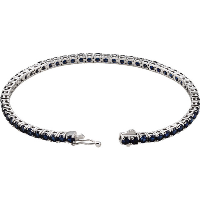 Dress her wrist in glittering style. Fashioned in 14K white gold, this exquisite bracelet pairs 3.0mm round-shaped blue sapphires, the traditional birthstone for September. The bracelet measures 7.25 inches in length.