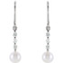 These elegant 14k gold earrings each feature a 6mm freshwater cultured pearl with diamond accents. Diamonds are 1/4ctw, G-H in color, and I1 or better in clarity. Earrings are 22.50mm in length and 2.25mm in width.