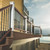 Deck with Trex Charcoal Black round balusters and white posts overlooking water Deck with Trex Charcoal Black round balusters and white posts overlooking water