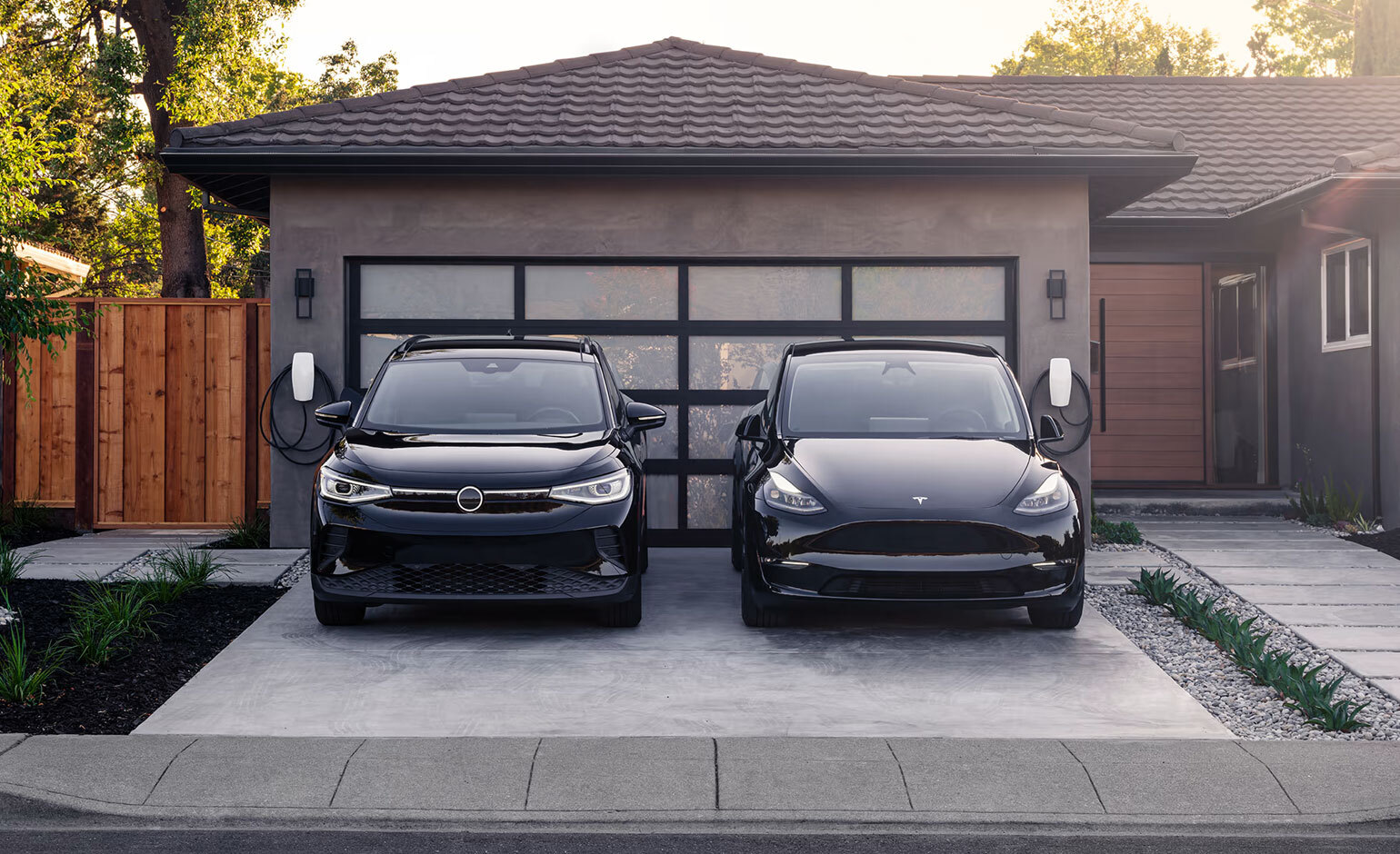 Tesla and other electric vehicle in front of garage